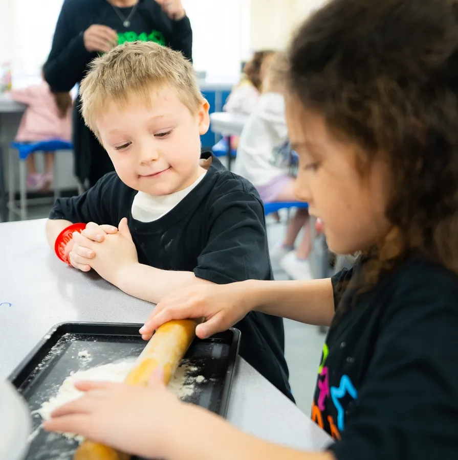 Child decorating a cupcake during a Billericay Holiday Camp cookery activity