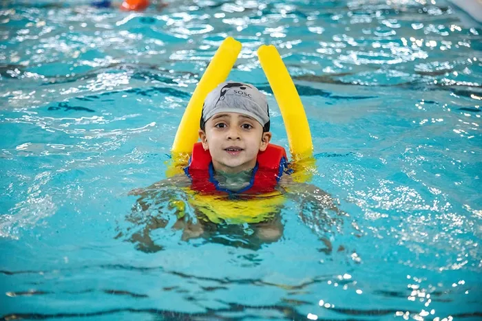 Ockendon Holiday Camp swimming activity at Harris Academy Ockendon Child swimming with pool noodles during Ockendon Holiday Camp at Harris Academy Ockendon