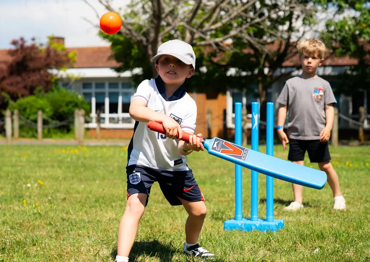 Child playing cricket outdoors during Ware Holiday Camp at Christ Church