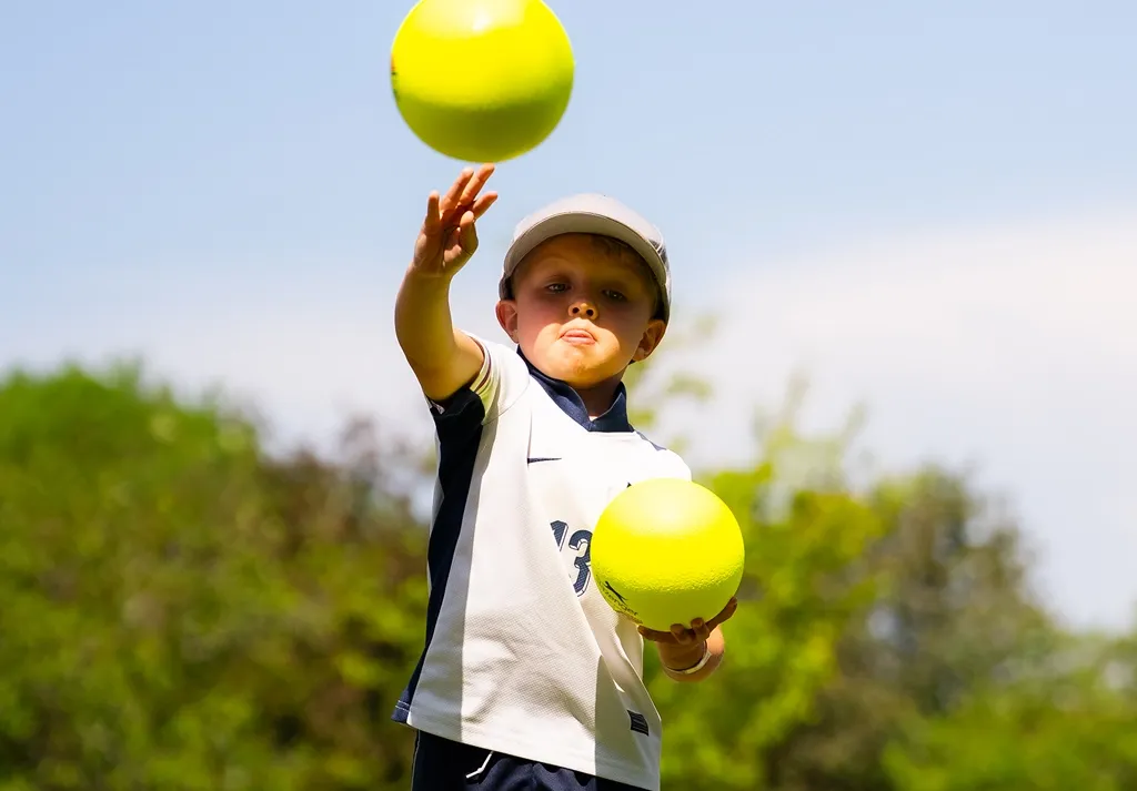 Child playing with yellow activity balls at a Camp 4 Champs holiday camp