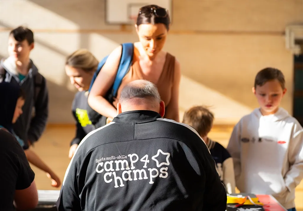 Camp 4 Champs staff member greeting families and children at holiday camp